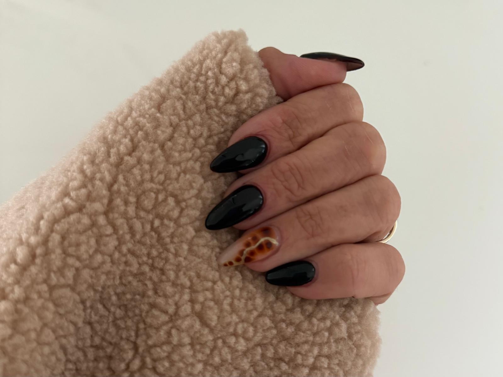 Glossy black almond nails with an animal print accent nail