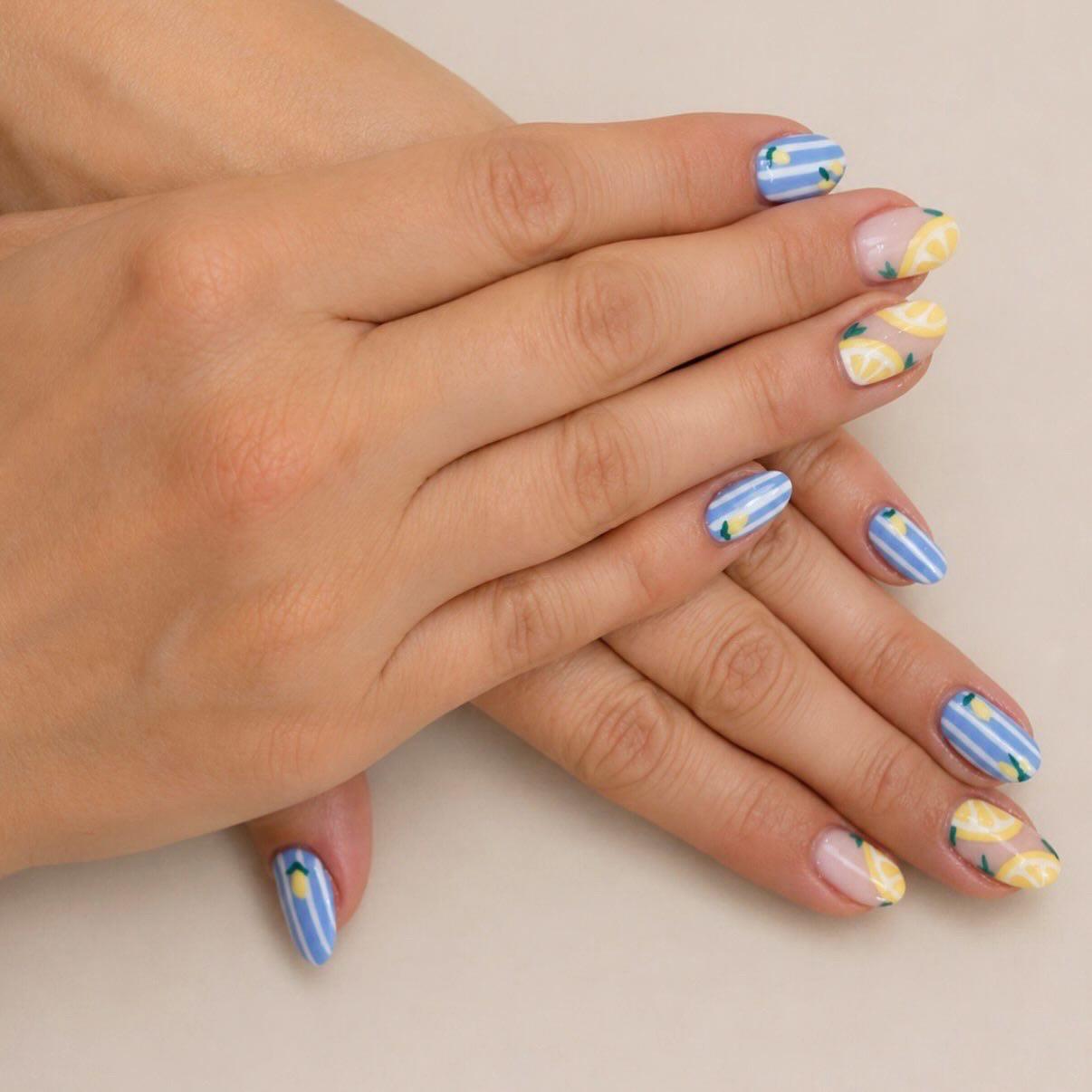 Blue striped and lemon print nail art on both hands