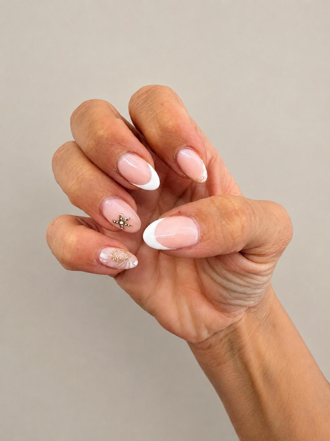 French tip nails with gold charm details