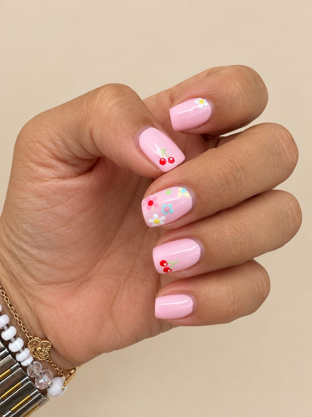 Baby pink gel nails with hand-painted cherries and daisies