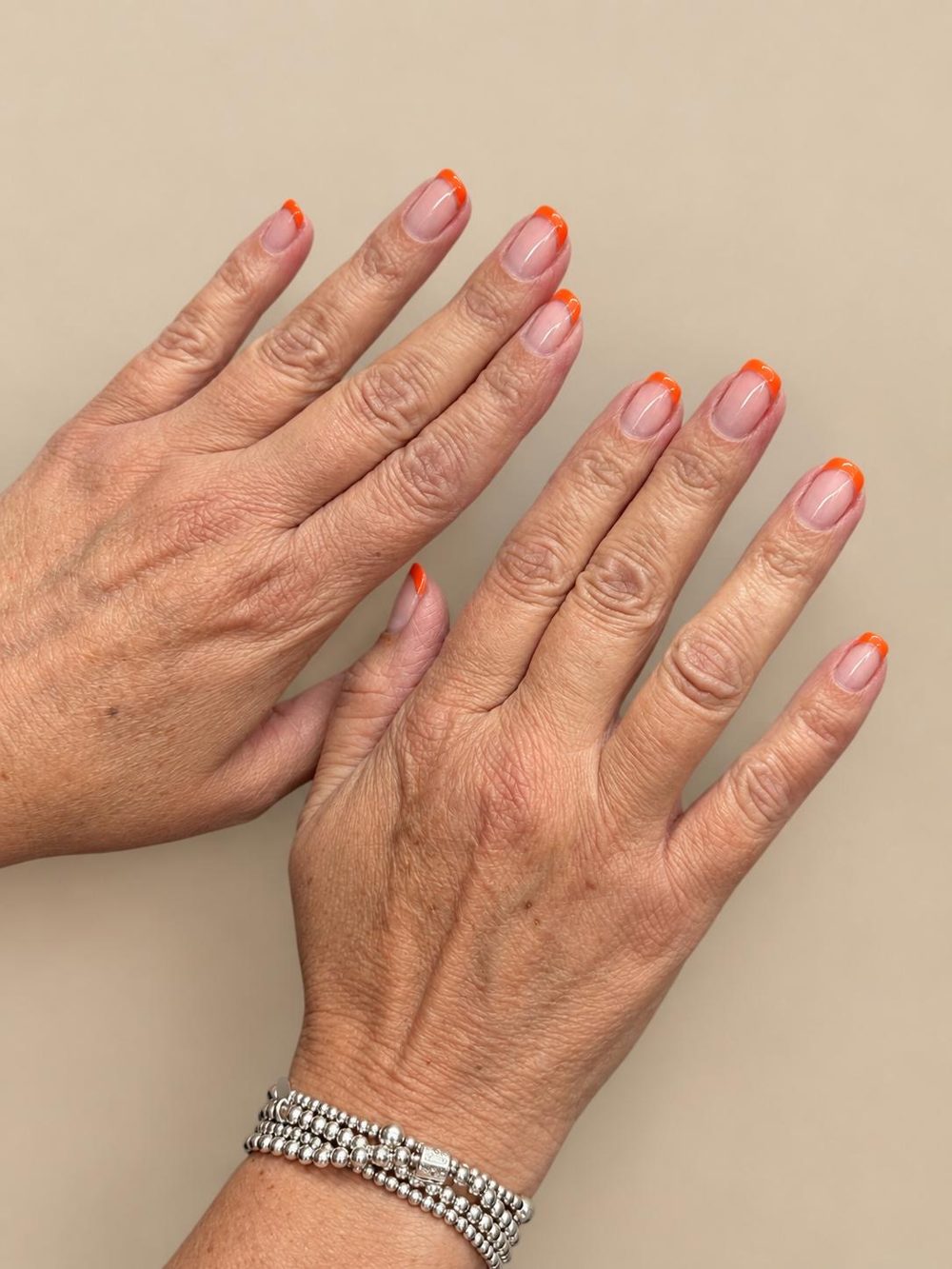 Bright orange French tips on short square nails
